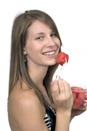 Girl against plain white background eating.  の写真素材