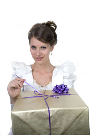 Young girl wears wedding dress and holds gift.  Photographed in studio.  の写真素材