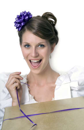 Young girl wears wedding dress and holds gift.  Photographed in studio.  の写真素材