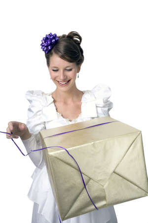 Young girl wears wedding dress and holds gift.  Photographed in studio.  の写真素材