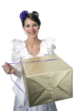 Young girl wears wedding dress and holds gift.  の写真素材