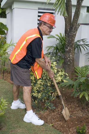 Senior does his own yard work.  He was also responsible for the construction of the yard and did all masonry work himself.  He is in his seventies.  Photographed in Bayamon, Puerto Rico.の写真素材