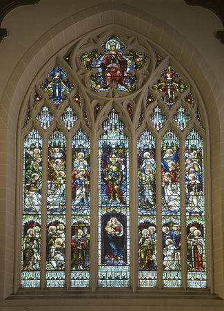 Christian stained glass showing saints, Mary with child, angels and Jesus crowned king.のeditorial素材