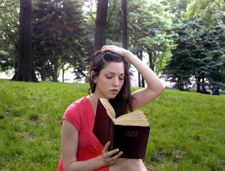 Girl with Bible in park.  Photographed in Central Park,  New York, USA.  She was in her twenties at the time of shoot.  Taken June, 2007. の写真素材
