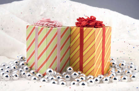 Some Christmas holiday presents photographed indoors against a snow type cloth background.の写真素材