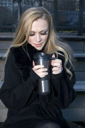 A Caucasian woman outdoors holding a thermos の写真素材