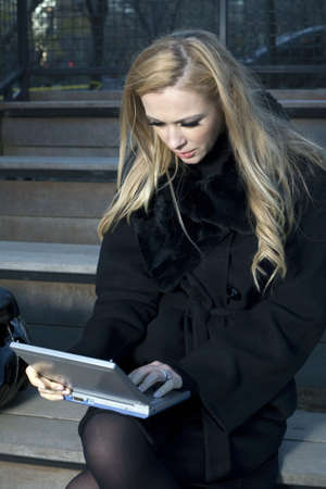 A Caucasian woman outdoors with her electronic device の写真素材