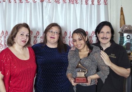 BRONX, NEW YORK - DECEMBER 23:  From left to right are Yomo Toro's niece Elizabeth, Yomo's wife Minerva, friend Katiria and nephew Eddie Toro with Latin Grammy  as they unite to remember international cuatro player Yomo Toro who was awarded the Grammy butのeditorial素材