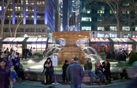 NEW YORK, NEW YORK, USA - DECEMBER 10: People sit near the fountain in Bryant Park.  Taken December...