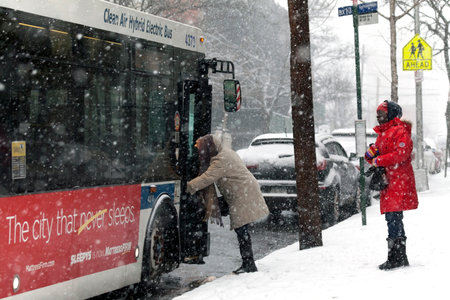 BRONX, NEW YORK -JANUARY 7: Woman boarding bus during snow storm.  Taken January 7, 2017 in New York.のeditorial素材