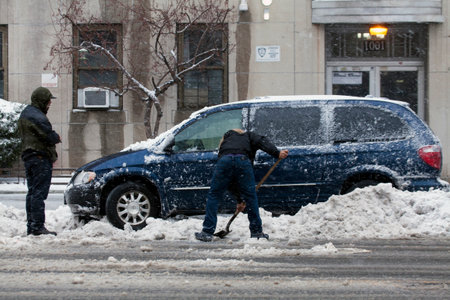 BRONX, NEW YORK - MARCH 14:  Man shovels to free car from snow.  Taken March 14, 2017 in New York.のeditorial素材