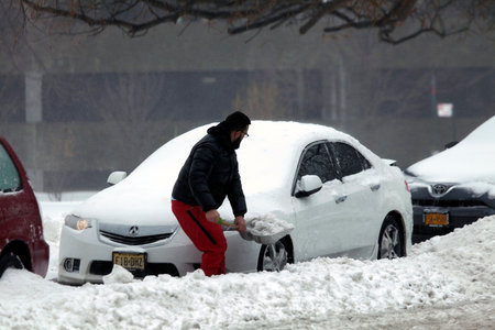 BRONX, NEW YORK - MARCH 14:  Man digs out car with shovel during snow storm.  Taken March 14, 2017 in New York.のeditorial素材