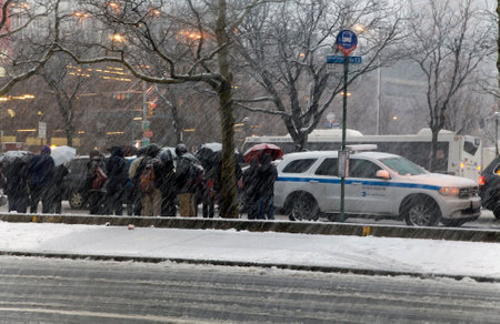 BRONX, NEW YORK - MARCH 7: A crowd of people wait for bus at Yankee Stadium in snow storm.  Taken March 7, 2018 in New York.のeditorial素材