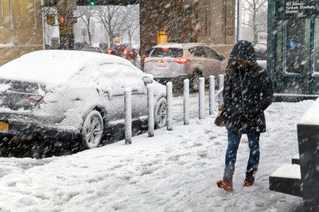 BRONX, NEW YORK - MARCH 7: Woman listens to electronic device near Yankee Stadium subway station during snow storm.  Taken March 7, 2018 in New York.のeditorial素材