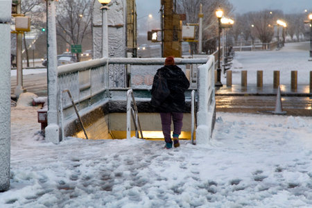 BRONX, NEW YORK - MARCH 7: Woman descend to underground subway station at Yankee Stadium during snow storm.  Taken March 7, 2018 in New York.のeditorial素材