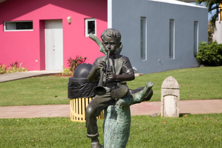 BAYAMON/PUERTO RICO - February 26, 2019: Statue of child playing trumpet inside Central park for kids "Parque de los ninos".のeditorial素材