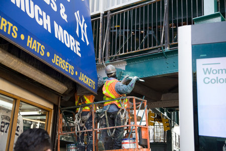 BRONX, NEW YORK/USA - March 27, 2019: MTA employee painting exterior of Yankee Stadium subway...