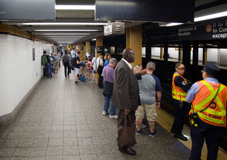 BRONX, NEW YORK/USA - May 19, 2019: Man seeks directions from transit personnel on subway platform.のeditorial素材