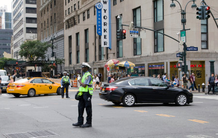 NEW YORK, NEW YORK/USA - July 2, 2019: NYPD agent directs traffic along busy Manhattan street.のeditorial素材