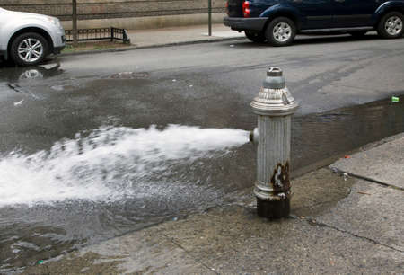 Fire hydrant left open in summer without water saving cap.の写真素材