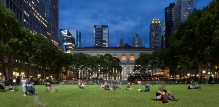 NEW YORK, NEW YORK/USA - June 10, 2018: People relax on lawn of Bryant Park at dusk.のeditorial素材