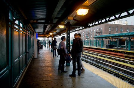 BRONX, NEW YORK/USA - September 25, 2018: Men wait for train at Yankee Stadium station on a rainy...