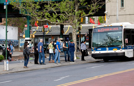 BRONX, NEW YORK, USA - May 18, 2020: People boarding local bus while wearing protective masks against Covid.のeditorial素材