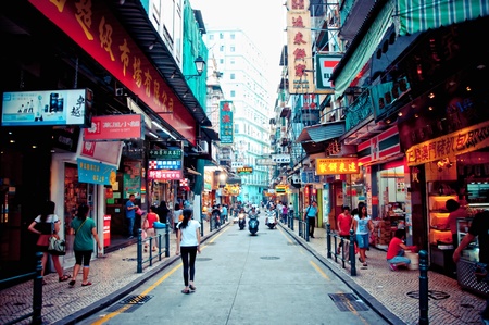 Macau, China - August 1, 2012: tourists and shoppers walking along a narrow street in central Macau with many shops and restaurantsのeditorial素材