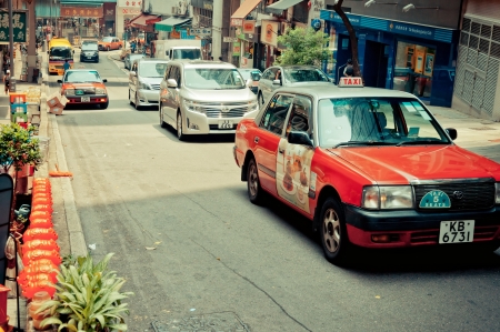 HONG KONG, CHINA - AUGUST 01: Street view with taxi, cars and shops on August 01, 2012 in Hong Kong, China. With 7M population and land mass of 1104 sq km, it is one of the most dense areas in the world のeditorial素材