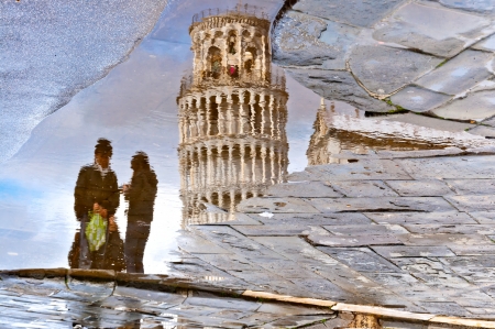 PISA, ITALY - MARCH 18  reflection of the leaning tower and couple of unidentified tourists in a puddle on March 18, 2013 in Pisa Place of Miracles is a UNESCO World Heritage Site since 1987のeditorial素材