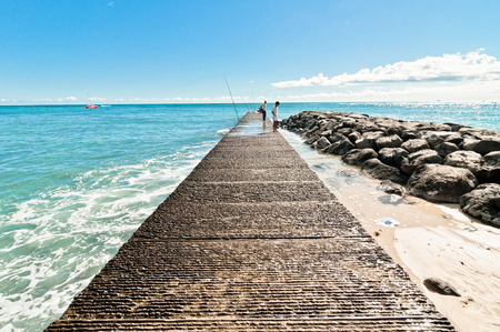 WAIKIKI, HAWAII - SEPTEMBER 7, 2013  fishermen on Waikiki beach pier in Honolulu, Hawaii  Waikiki white sand beach shoreline is Hawaii s most famous beachのeditorial素材