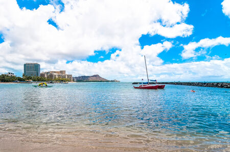 WAIKIKI, HAWAII - SEPTEMBER 7, 2013  Tourists sunbathing and surfing on Waikiki beach in Honolulu,...