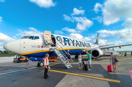 PISA, ITALY - AUGUST 21, 2014: passengers deplane Ryanair Jet airplane after landing in Pisa airport, Italy. Ryanair is the biggest low-cost airline company in the world.のeditorial素材