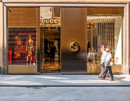 FLORENCE, ITALY - March 21, 2014: tourists walk in front of Gucci Shop in Florence, Italy. Florence is home to some of the most famous works of art on earth.のeditorial素材