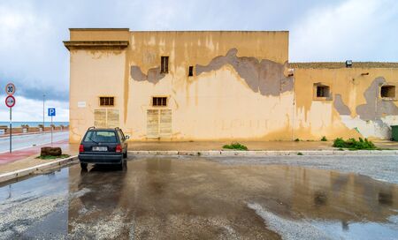 MARSALA, ITALY - FEBRUARY 22, 2014: day view of coastline and street with parked car and reflection in Marsala, Italy. The town is famous for the docking of Garibaldi on 11 May 1860 and for its wine.のeditorial素材