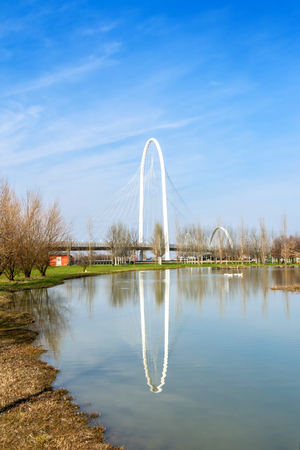 REGGIO EMILIA, ITALY - MARCH 9, 2015: bridges complex by architect Santiago Calatrava reflected in pound in Reggio Emilia, Italy. The central arch of the bridge is 220 meters long and 50 meters highのeditorial素材