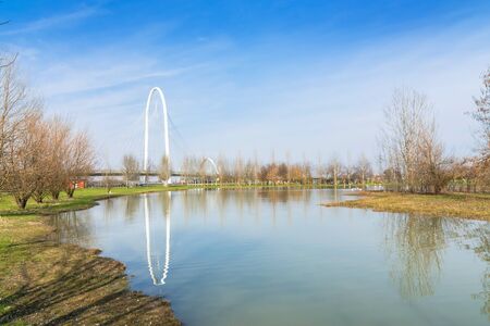 REGGIO EMILIA, ITALY - MARCH 9, 2015: bridges complex by architect Santiago Calatrava reflected in pound in Reggio Emilia, Italy. The central arch of the bridge is 220 meters long and 50 meters highのeditorial素材
