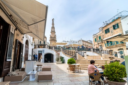OSTUNI, ITALY - MAY 16, 2015: tourists visit old town and Statue of San Oronzo in Ostuni, Italy. Ostuni is one of the most beautiful and famous towns in Apulia.のeditorial素材