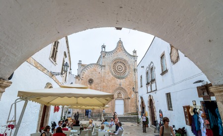 OSTUNI, ITALY - MAY 16, 2015: day view of white street with Cathedral in Ostuni, Italy. Ostuni is one of the most beautiful and famous towns in Apulia.のeditorial素材