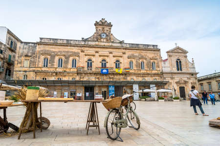 OSTUNI, ITALY - MAY 16, 2015: day view of old knife grinder bicycle and main square in Ostuni, Italy. Ostuni is one of the most beautiful and famous towns in Apulia.のeditorial素材