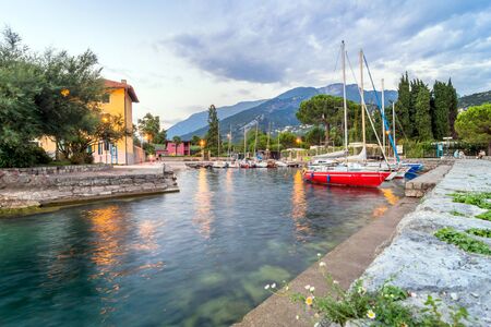 Torbole, Italy - August 2, 2015: Lake Garda boardwalk with tourists and boats in Torbole, Italy. Torbole is one of the most popular towns on Garda Lake, known as a wind surfers paradise.のeditorial素材