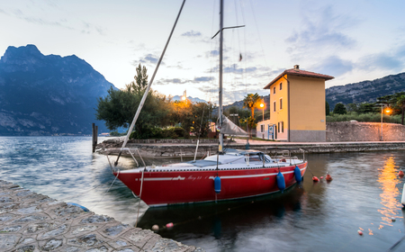 Torbole, Italy - August 2, 2015: Lake Garda boardwalk with boat in Torbole, Italy. Torbole is one of the most popular towns on Garda Lake, known as a wind surfers paradise.のeditorial素材