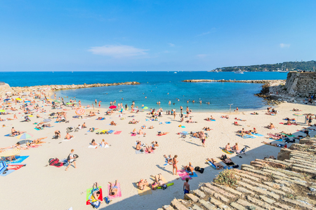 Antibes, France - July 01, 2016: people sunbathing on Plage de la Gravette in Antibes. It is a popular local beach, a long stretch of fine, white sand at the end of the port.のeditorial素材