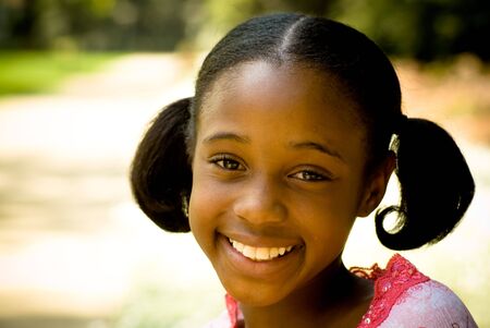 young african-american girl smiling very contently with ponytails.の写真素材