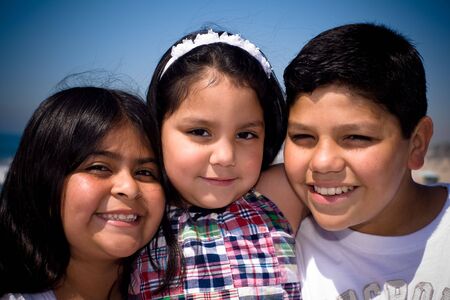 a hispanic family takes a shot together at the beachの写真素材
