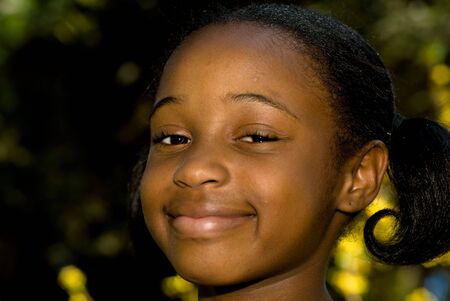 A young african american girl outdoors with a big smileの写真素材