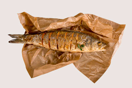 fish served with tomatoes and vegetables on big wooden board over tableの写真素材