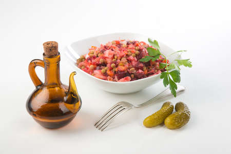 Russian beetroot salad Oilcan cucumbervinaigrette White plate on checkered napkin on wood backgroundの写真素材