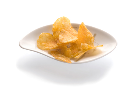 Salted chips on white porcelain bowl, isolated on whiteの写真素材