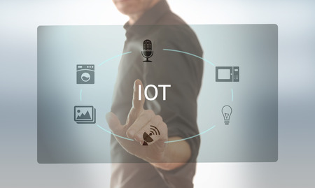 A man taps on a screen with icons on the subject of IOTの写真素材